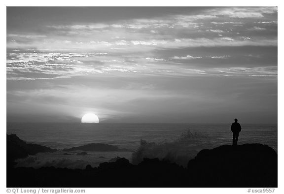 Man watching sunset over ocean. Pacific Grove, California, USA (black and white)