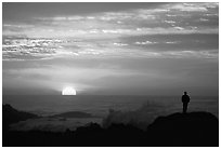 Man watching sunset over ocean. Pacific Grove, California, USA (black and white)