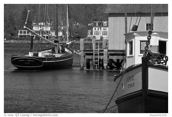 Historic boats, Mystic River, and houses. Mystic, Connecticut, USA