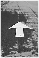 Painted arrow, asphalt, and sand, Cape Cod National Seashore. Cape Cod, Massachussets, USA ( black and white)