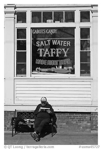 Man reading in front of Salt Water taffy store, Provincetown. Cape Cod, Massachussets, USA (black and white)