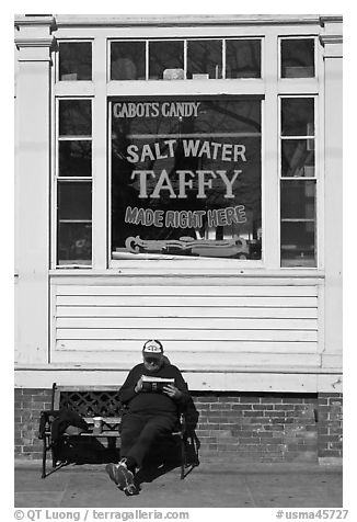 Man reading in front of Salt Water taffy store, Provincetown. Cape Cod, Massachussets, USA (black and white)