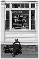 Man reading in front of Salt Water taffy store, Provincetown. Cape Cod, Massachussets, USA (black and white)