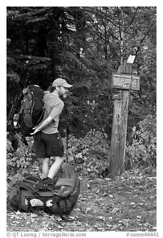 Backpacker shouldering pack at trailhead. Maine, USA (black and white)