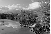 Trees in fall foliage reflected in wide  Penobscot River. Maine, USA (black and white)