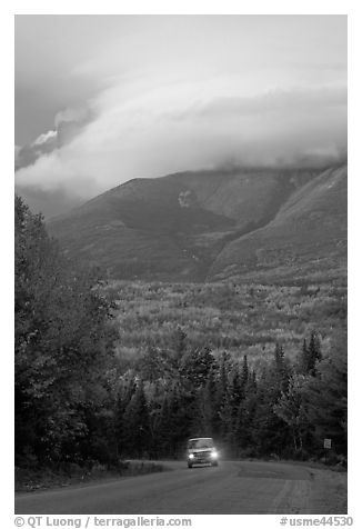 Truck on road below cloud-capped Katahdin. Maine, USA