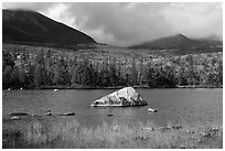 Boulder, pond, forest in autumn and mountains with clouds. Baxter State Park, Maine, USA ( black and white)