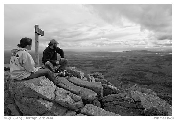 Hikers taking in view near sign marking summit of South Turner Mountain. Baxter State Park, Maine, USA (black and white)