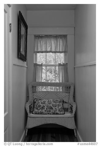 Corridor in inn with chair and window looking out to trees. Maine, USA
