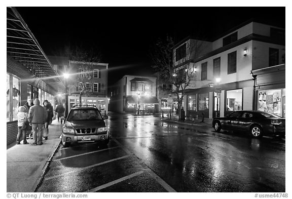 Street at night with people standing on sidewalk. Bar Harbor, Maine, USA (black and white)