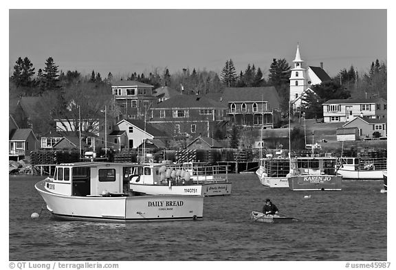 Lobsterman paddling towards boat. Corea, Maine, USA (black and white)