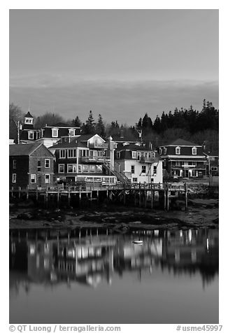 Houses with lights reflected in harbor. Stonington, Maine, USA (black and white)