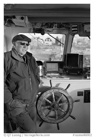 Captain of Isle-au-Haut mailboat aboard boat. Isle Au Haut, Maine, USA (black and white)