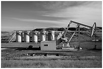 Pumping unit and tanks, oil well. North Dakota, USA (black and white)