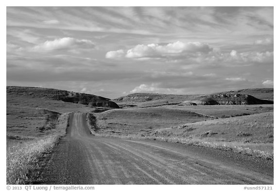 Gravel road, rolling hills and badlands. North Dakota, USA (black and white)