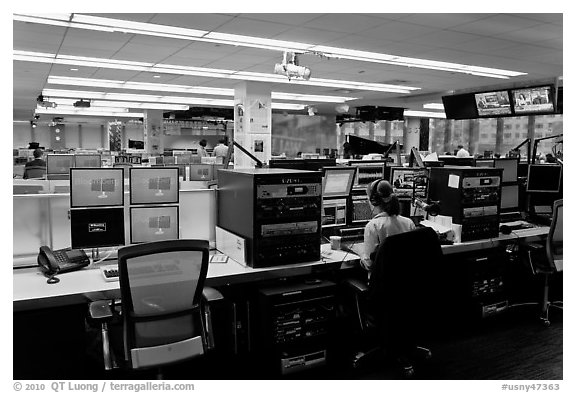 Bloomberg News analyst working in front of many screens. NYC, New York, USA