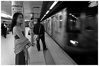 Young woman and arriving train on subway platform. NYC, New York, USA (black and white)