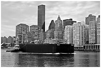 Barge on Hudson River and Manhattan waterfront. NYC, New York, USA (black and white)