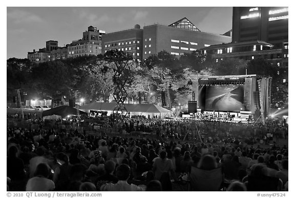 Outdoor musical performance at night with QTL photo as screen backdrop, Central Park. NYC, New York, USA (black and white)