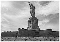 Statue of Liberty from lawn with pigeons, Statue of Liberty National Monument. NYC, New York, USA ( black and white)