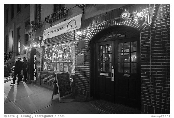 Two men on sidewalk and Stonewall Inn at night, Stonewall National Monument. NYC, New York, USA (black and white)