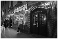 Two men on sidewalk and Stonewall Inn at night, Stonewall National Monument. NYC, New York, USA ( black and white)