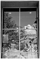 Cliff and sculptures reflected in a window, Mount Rushmore National Memorial. South Dakota, USA (black and white)