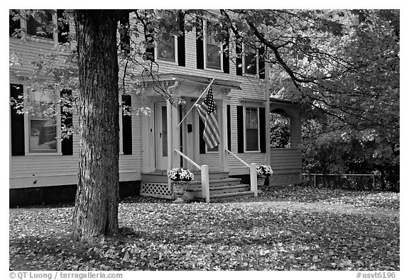 House with American flag and red leaves. Vermont, New England, USA