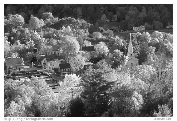 Village surounded by trees in brilliant autumn foliage. Vermont, New England, USA