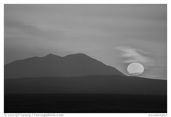 Sun rising and Big Southern Butte. Craters of the Moon National Monument and Preserve, Idaho, USA (black and white)
