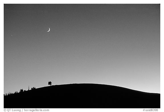 Curve of cinder cone, pastel sky, and moon, Craters of the Moon National Monument. Idaho, USA