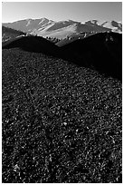 Dark pumice, cinder cones, and Pioneer Mountains. Craters of the Moon National Monument and Preserve, Idaho, USA ( black and white)