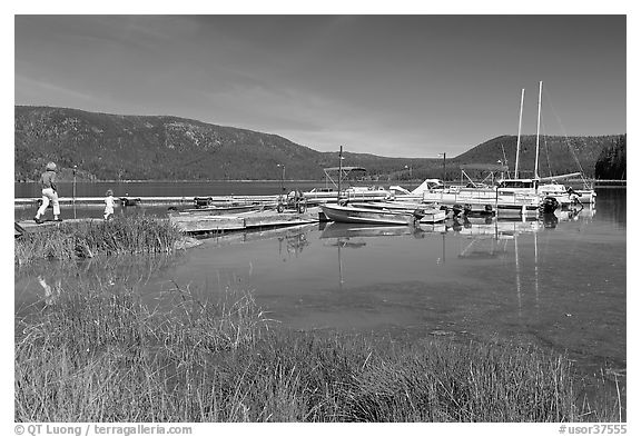 Family walking on deck towards boats, Paulina Lake. Newberry Volcanic National Monument, Oregon, USA (black and white)