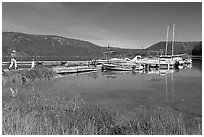 Family walking on deck towards boats, Paulina Lake. Newberry Volcanic National Monument, Oregon, USA (black and white)