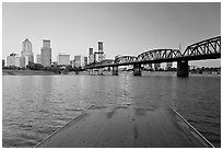 Deck, and Portland skyline with bridge at sunrise. Portland, Oregon, USA (black and white)