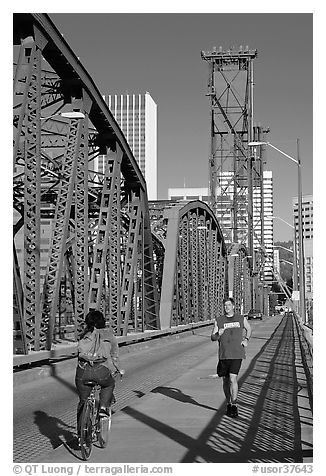 Jogger and cyclist on Hawthorne Bridge. Portland, Oregon, USA (black and white)