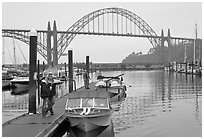 Couple holds  small boat on pier, Newport Marina. Newport, Oregon, USA ( black and white)