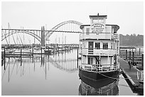 Couple walking on deck next to floating Bed and Breakfast. Newport, Oregon, USA ( black and white)