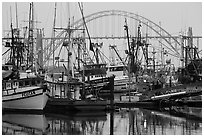 Commercial fishing boats and Yaquina Bay Bridge at dawn. Newport, Oregon, USA (black and white)