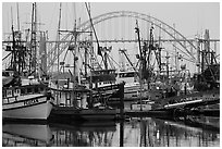 Commercial fishing boats and Yaquina Bay Bridge at dawn. Newport, Oregon, USA ( black and white)