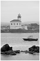 Small boat and Coquille River lighthouse. Bandon, Oregon, USA (black and white)