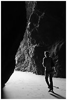 Woman walking out of sea cave. Bandon, Oregon, USA ( black and white)