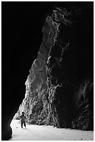 Infant walking into sea cave. Bandon, Oregon, USA (black and white)
