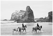 Women horse-riding on beach. Bandon, Oregon, USA (black and white)