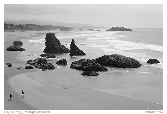 Beach at Face Rock with two people walking. Bandon, Oregon, USA