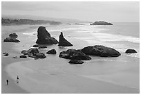 Beach at Face Rock with two people walking. Bandon, Oregon, USA (black and white)