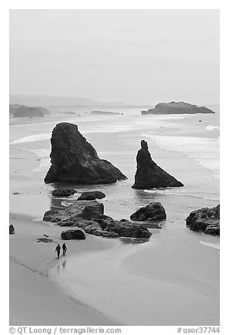 Beach with couple walking amongst sea stacks. Bandon, Oregon, USA (black and white)