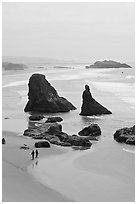 Beach with couple walking amongst sea stacks. Bandon, Oregon, USA (black and white)