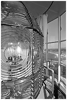 Rotating light inside Cape Blanco Lighthouse tower and landscape. Oregon, USA (black and white)