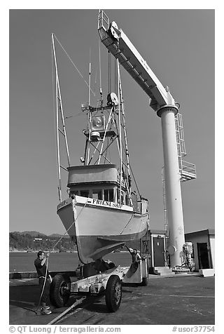 Fishing boat lifted from water by huge hoist, Port Orford. Oregon, USA